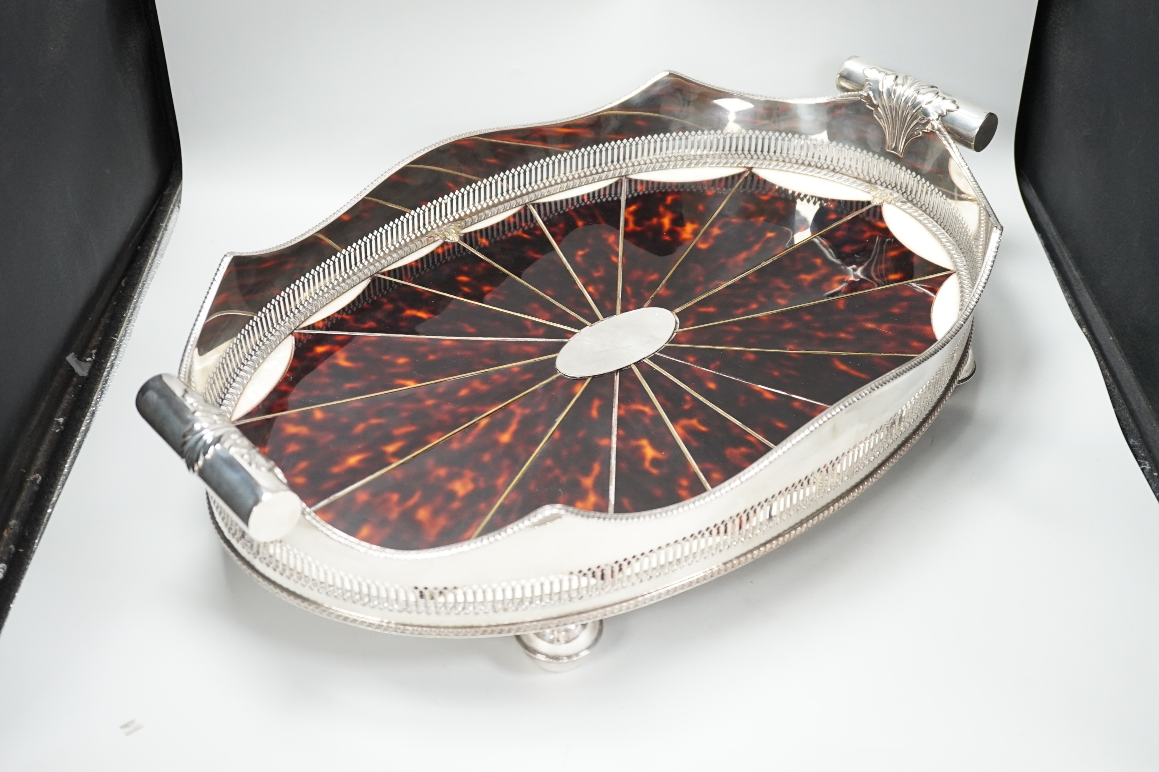 An unusual Adam style tortoiseshell and mother-of-pearl inlaid plated oval with ‘paterae’ decoration, 65cm wide